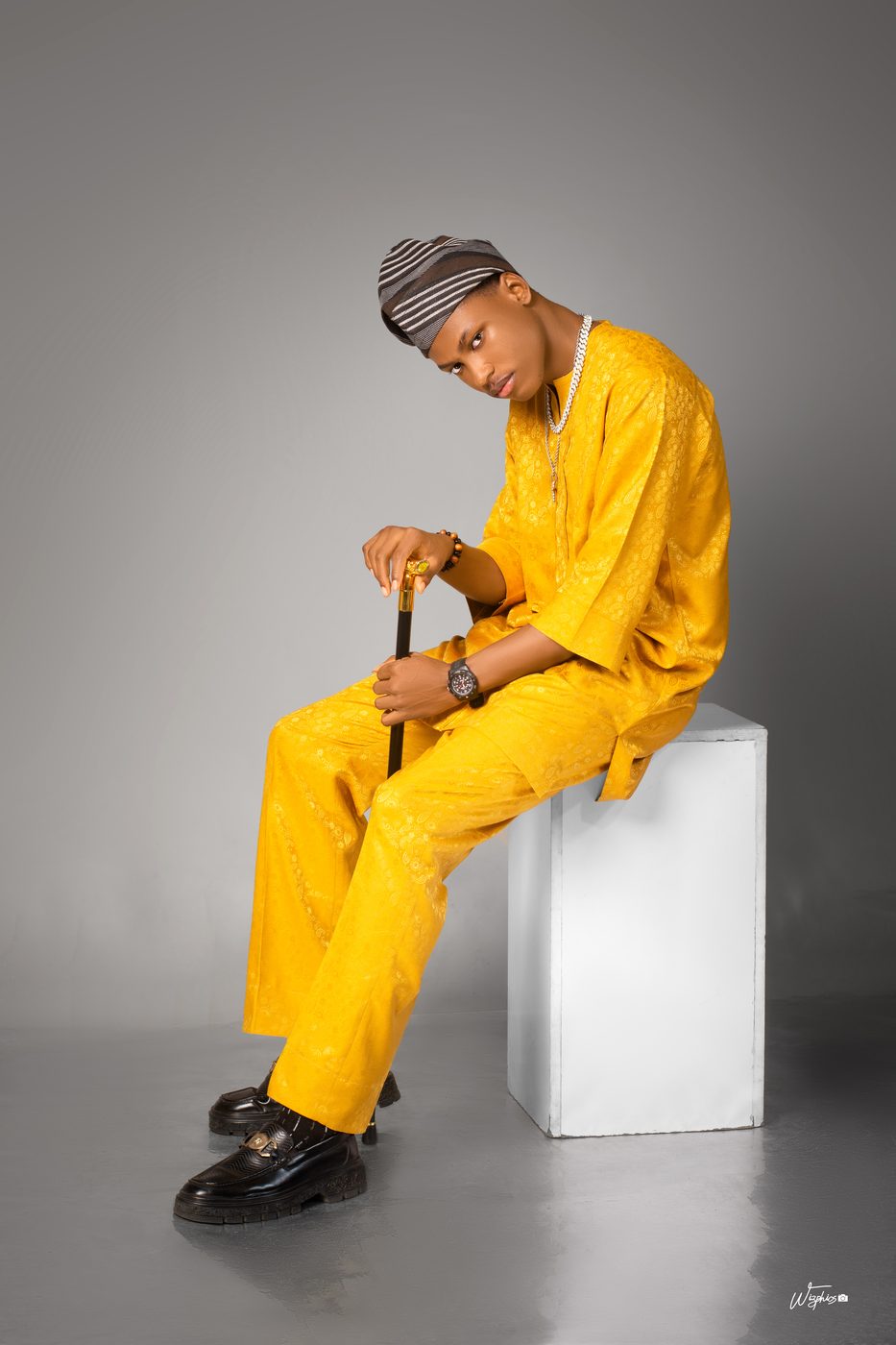 Editorial menswear, seated with cane